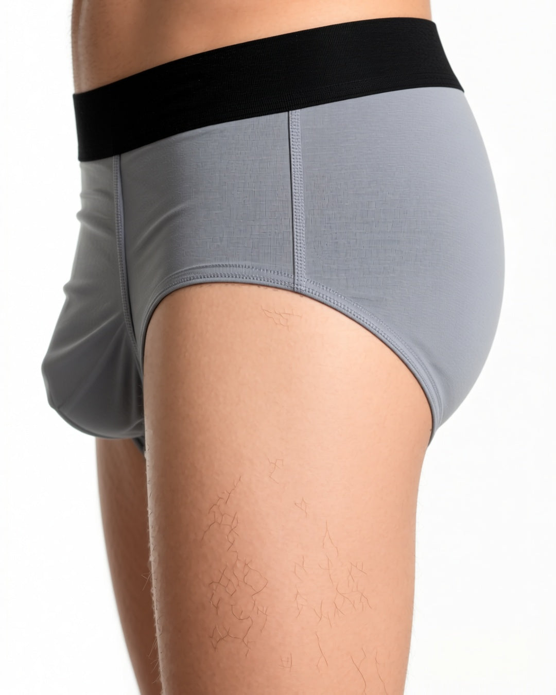 Men's Ultra-Thin Low-Rise Briefs with 3D Pouch in Grey, detail close-up of the waistband and the side seam of the brief at the hip. onmodel