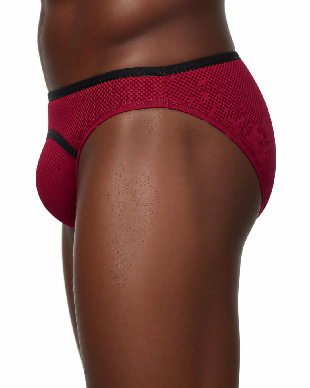 Men's Low-Rise U-Pouch Mesh Briefs in Burgundy, detail close-up of the waistband and the side seam of the brief at the hip. onmodel