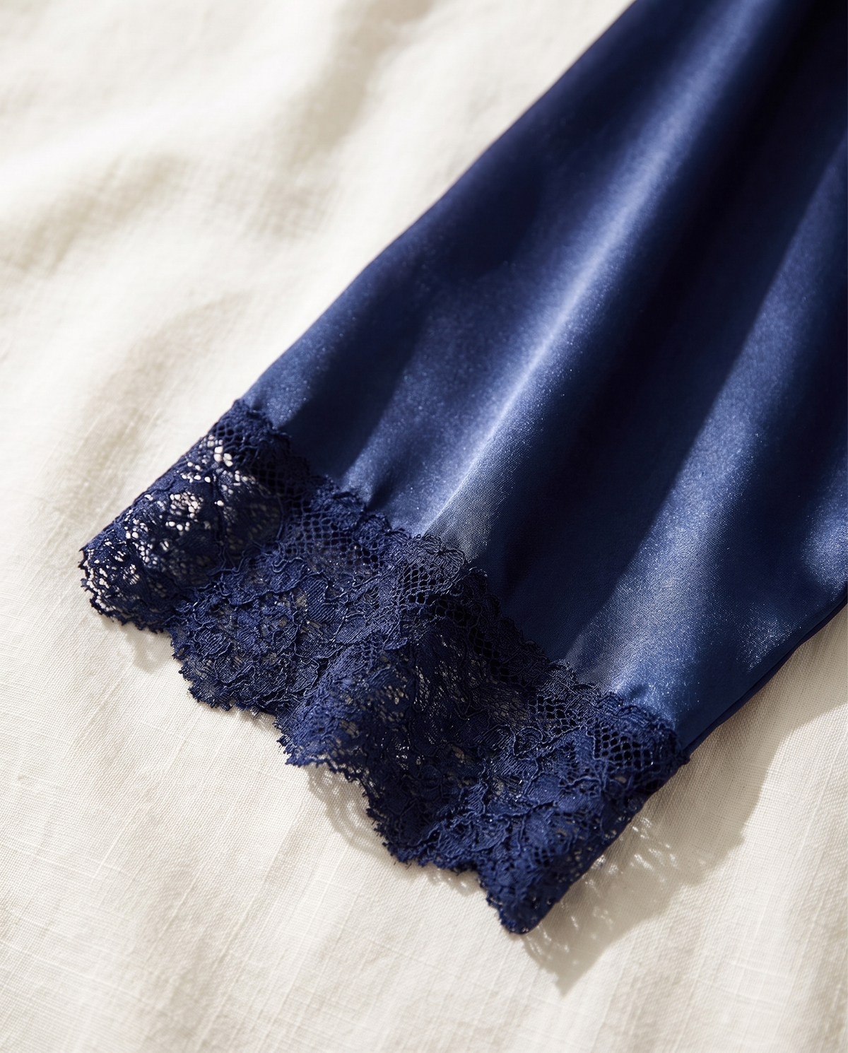 Close-up of the navy lace cuff on a wide satin sleeve