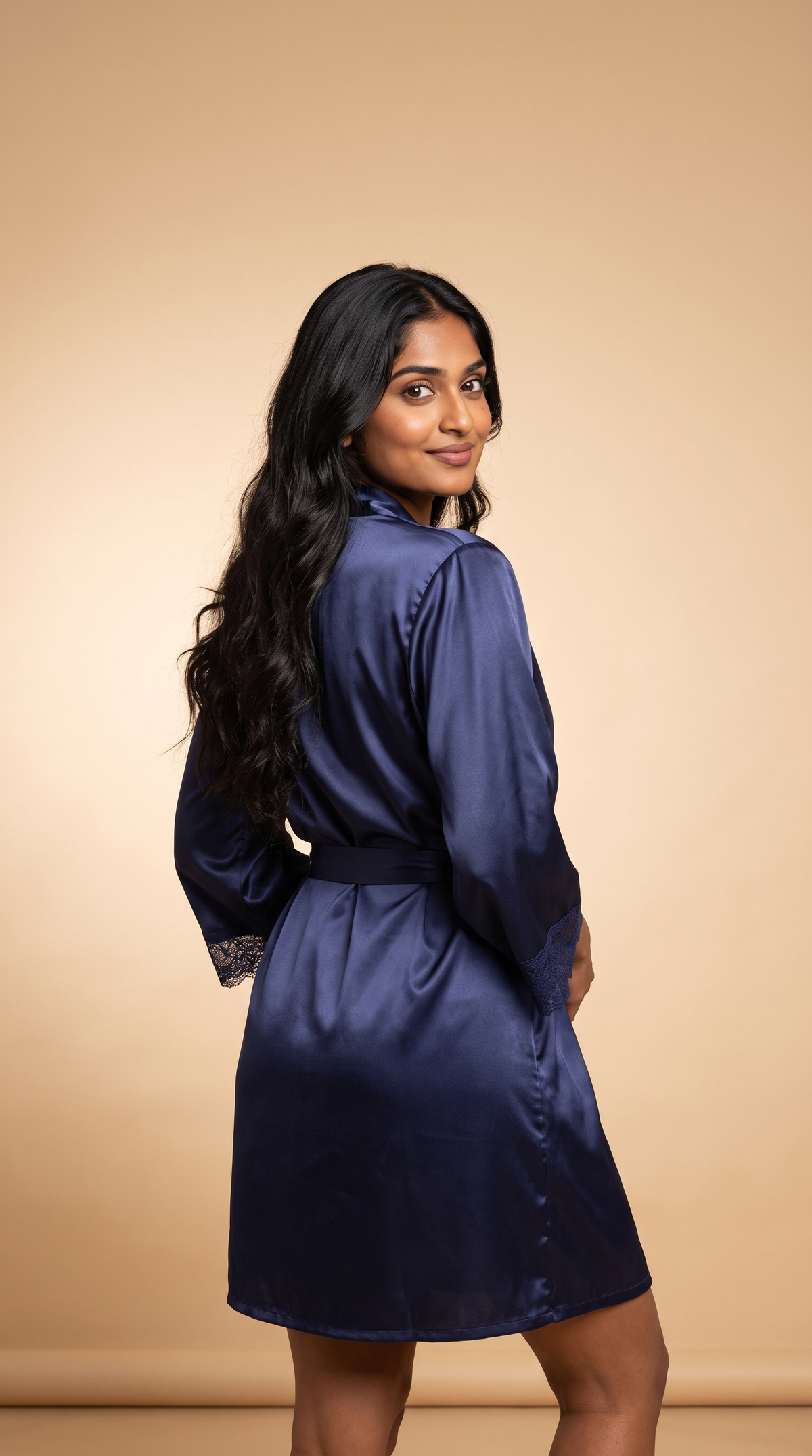 Back view: woman in the navy satin robe with the tie belt, looking over her shoulder